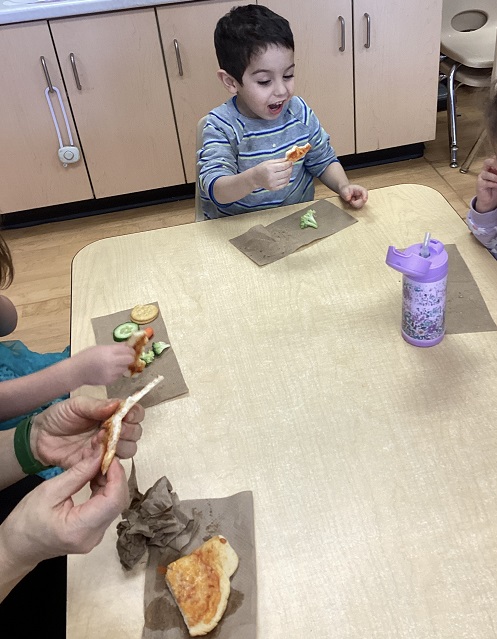 child sitting and enjoying homemade pizza