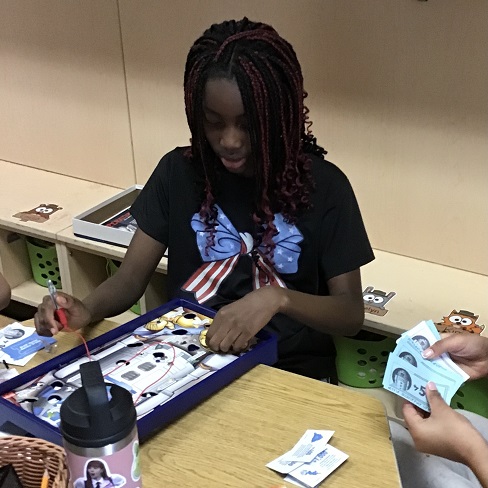 child at a table playing the game Operation