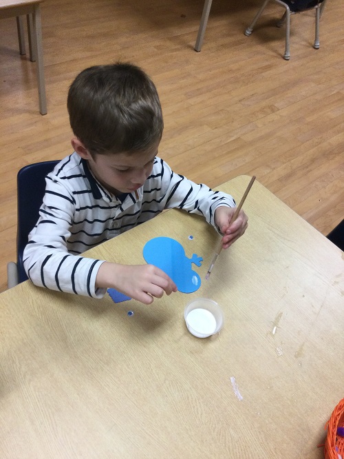 boy decorating blue snowman