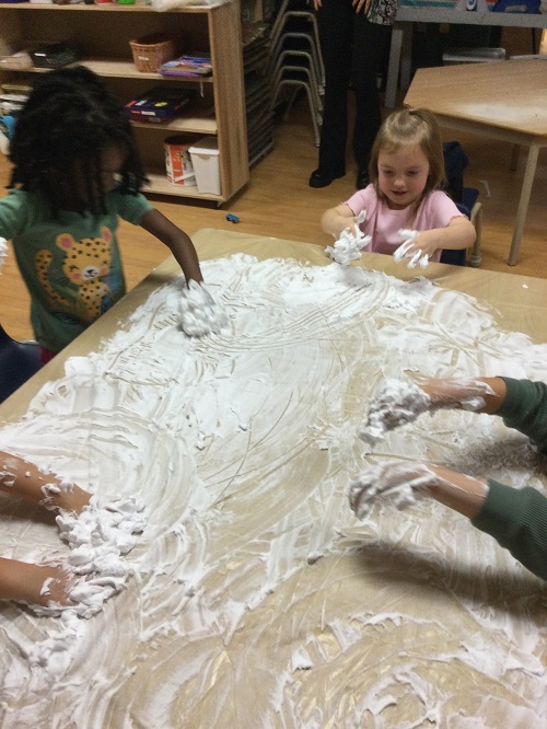 blonde girl pink shirt and brown hair girl in green shirt shaving cream