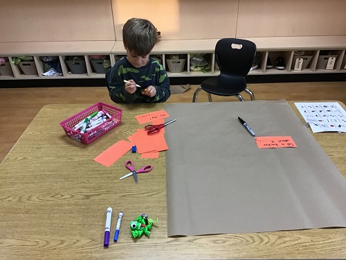 single child writing on orange paper