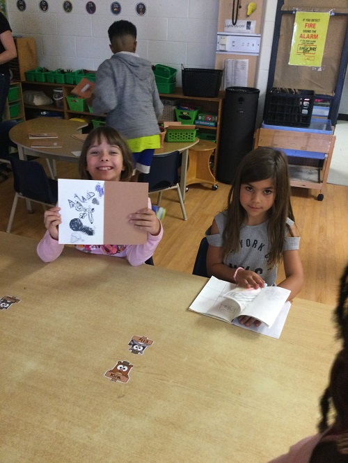 2 children showing their journals