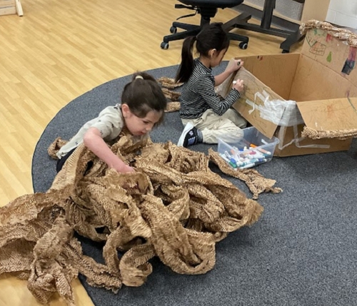 The children demonstrated creativity and problem-solving skills as they manipulated the paper packing materials to construct a wide range of purposeful and imaginative creations.