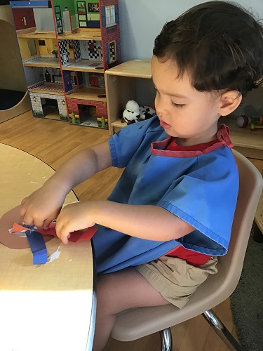 Matthias using his hands to stick down the paper fealthers