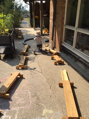 A toddler is riding their bike through the toddler track.