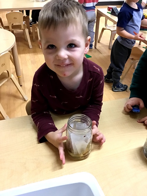 Child holding up jar