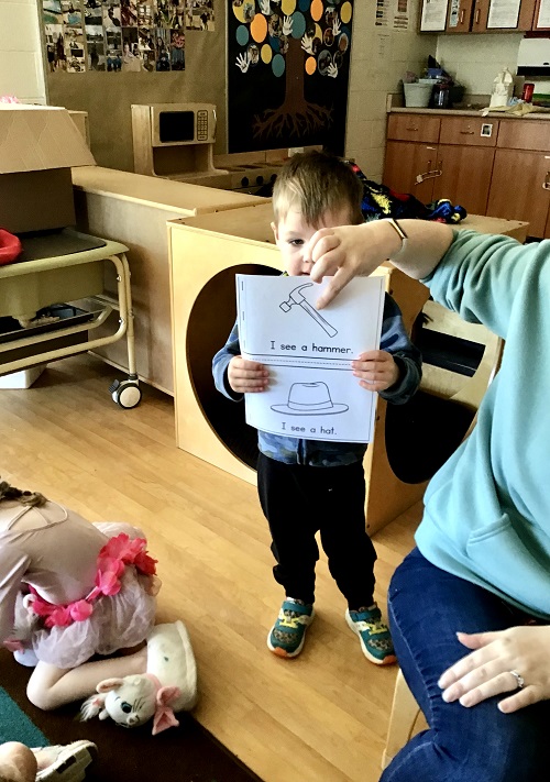 child holding up letter matching sheet