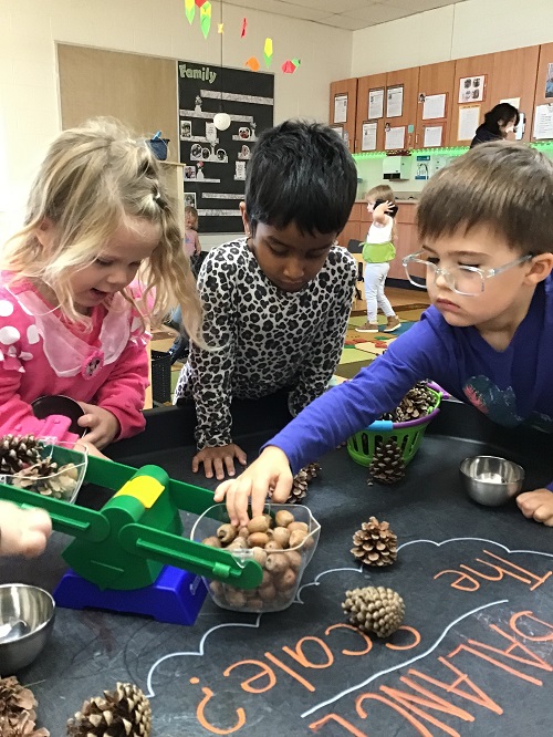 children using a scale to balance objects