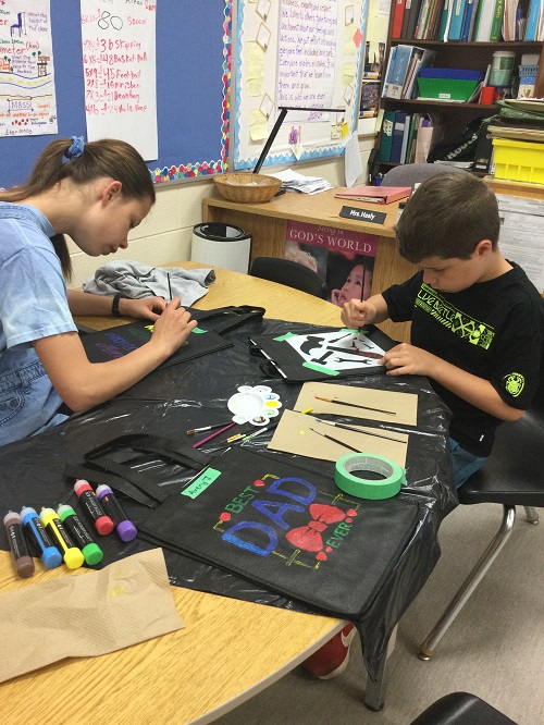 two children working on their tote bags