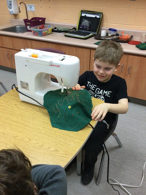 Child working to sew their pillow