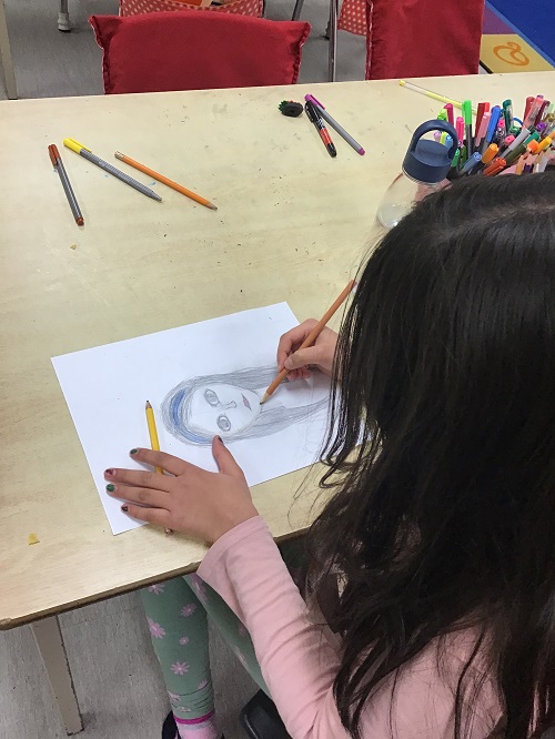 a child drawing a self-portrait