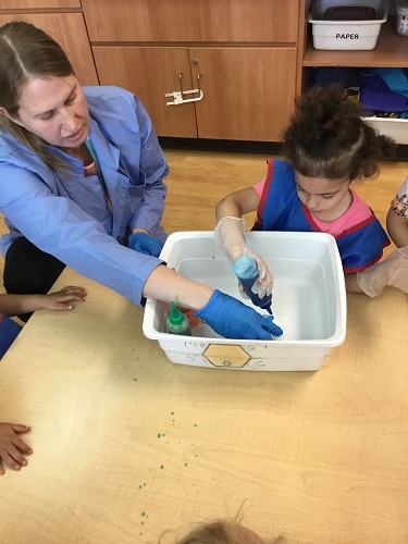 Child using a squeeze bottle for tye-dye