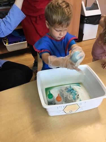 child squeezing tye-dye onto an object