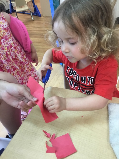 Child using scissors to cut paper
