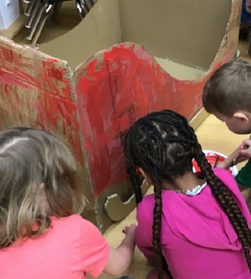 children painting cardboard