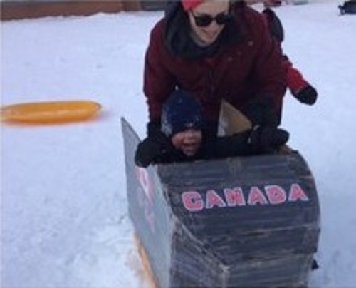 child riding down our homemade bobsleigh hill