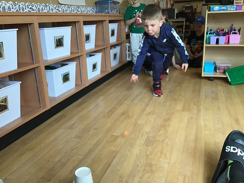 child rolling a bouncy ball on the floor