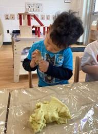 child molding a bear shape with clay