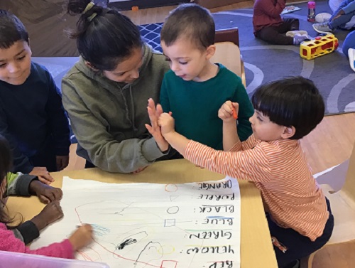 Child giving high five to an educator.