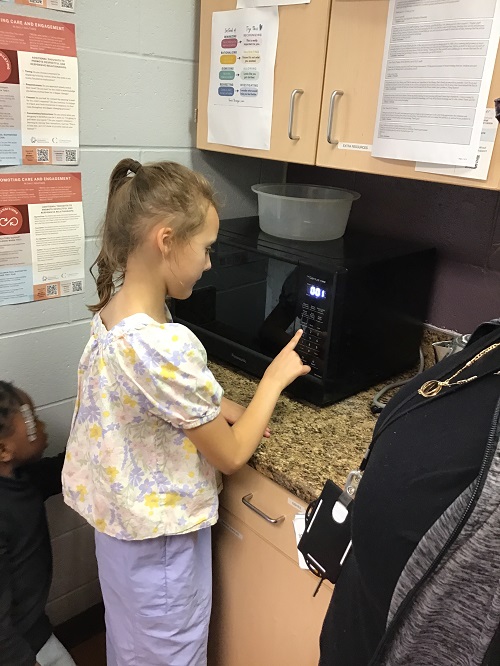 Child inputting numbers on the microwave.