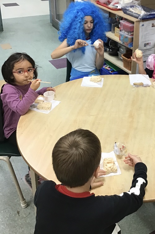 Children decorating and eating their rice krispies treat. 