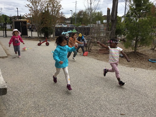 Children testing out their kites on the playground. 