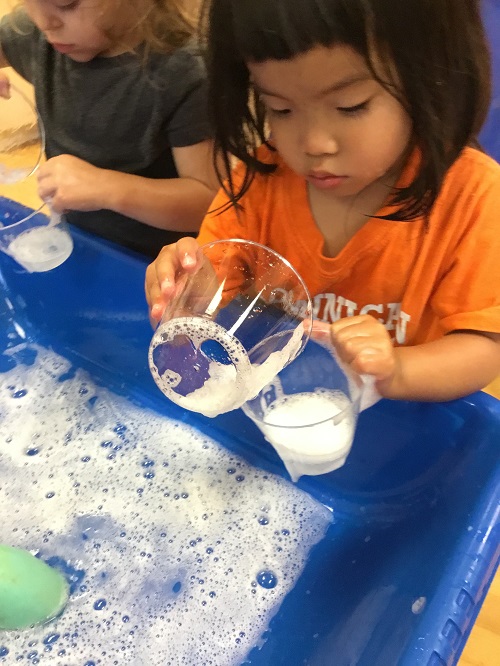 Children exploring soapy water.