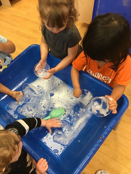 Children exploring soapy water. 