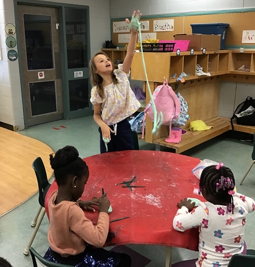 Child showing their stretched out slime.