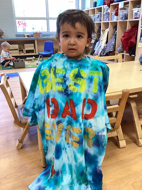 Child showing their colourful father's day shirt.