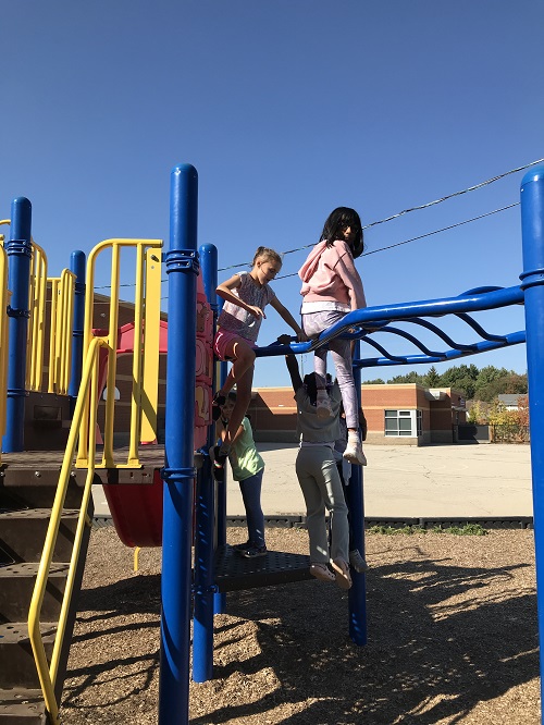 Children climbing on the monkey bars.