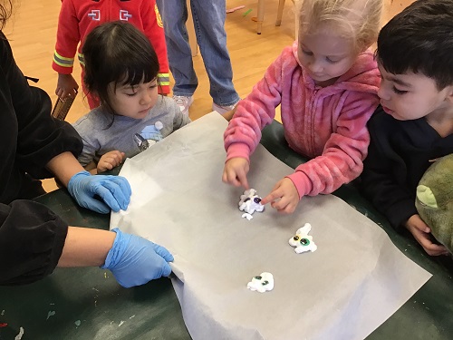 Children exploring making shaving cream ghosts.