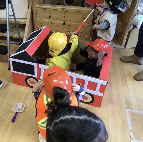 Children pretending to out fire out from the firetruck.