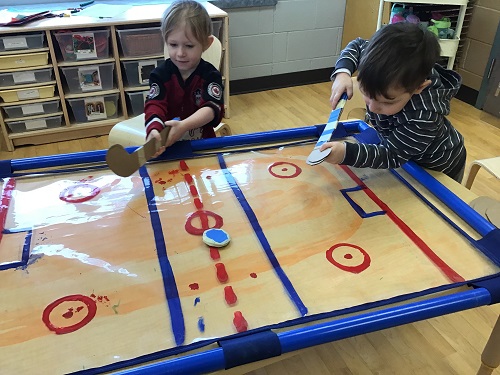 Children engaged in a table hockey game.