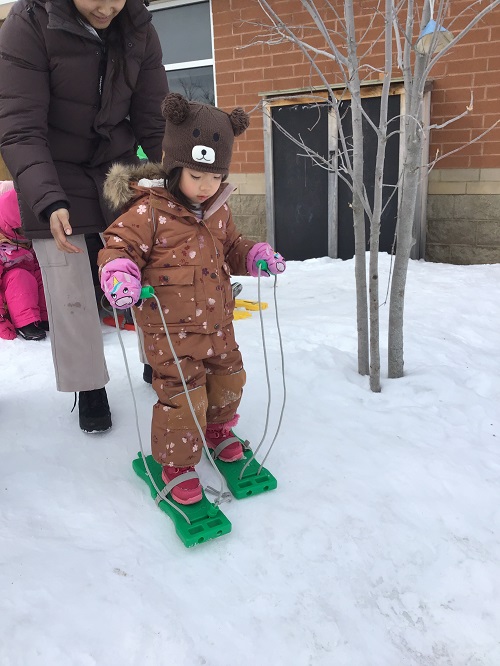 Child practicing cross country skiing.
