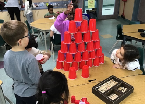 Child making a tower out of solo cups.