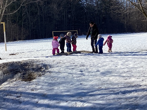 Children standing on the discovered rocks with an educator.