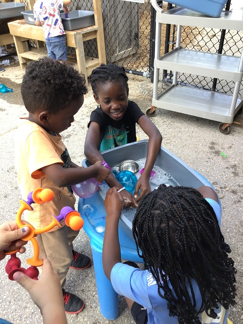 Children sitting at the table making "potions."