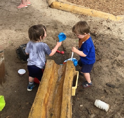 Children collecting water at the bottom of the water feature.