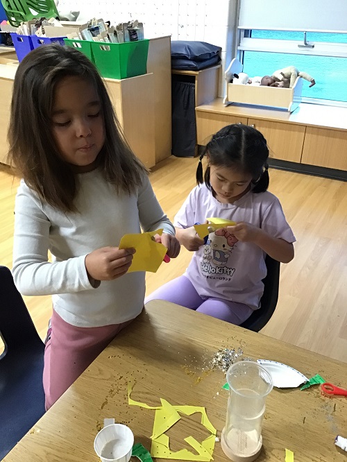 Children cutting shapes out of paper.