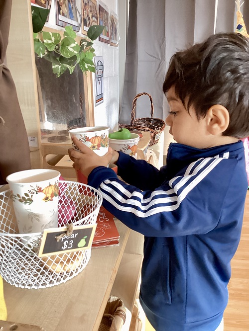 A preschool child playing in their farmers market