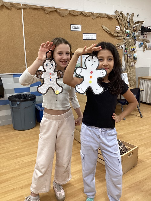 Two children showing their artwork.