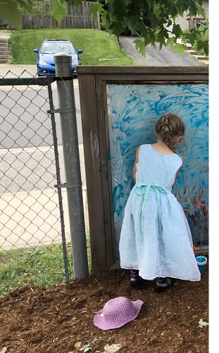 Preschooler painting outside