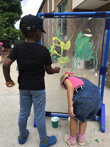 Two Preschoolers painting outside
