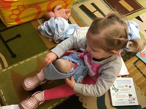 Toddler caring for baby doll
