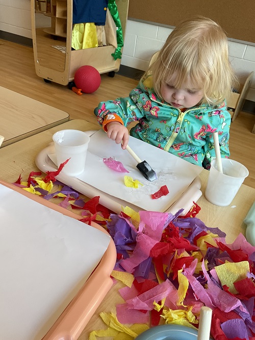 little girl gluing tissue