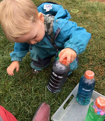 Toddler looking at sensory bottle