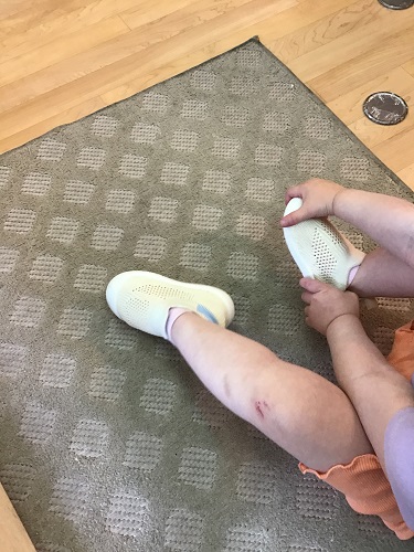 An infant removing their shoes