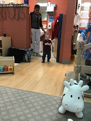 An infant taking steps in the classroom