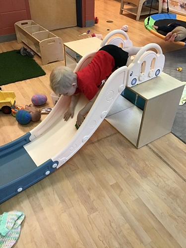 Child slidding down a slid head first